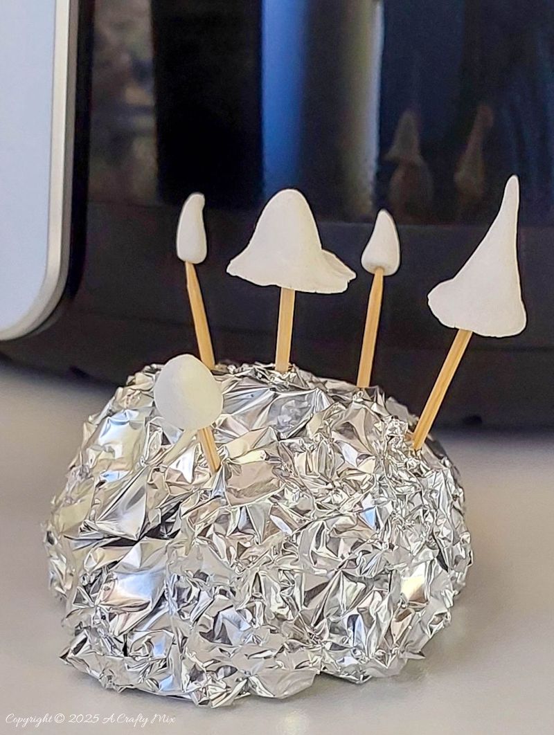 Use a toothpick and stick the clay creations in a ball of foil to keep them from blowing away