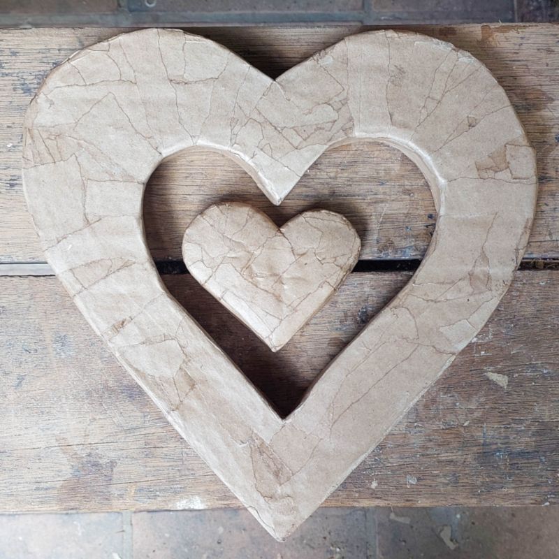 Two cardboard hearts after apply the paper strips