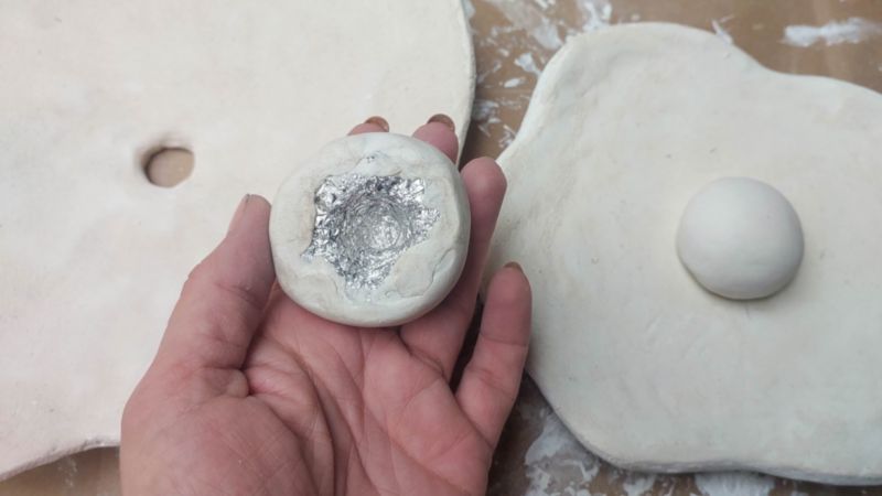 Roll out a clay circle and place it over the aluminium dome