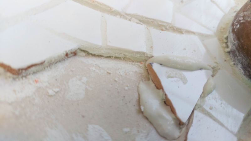 Put tile adhesive on the back of the tile and add it to the flower base