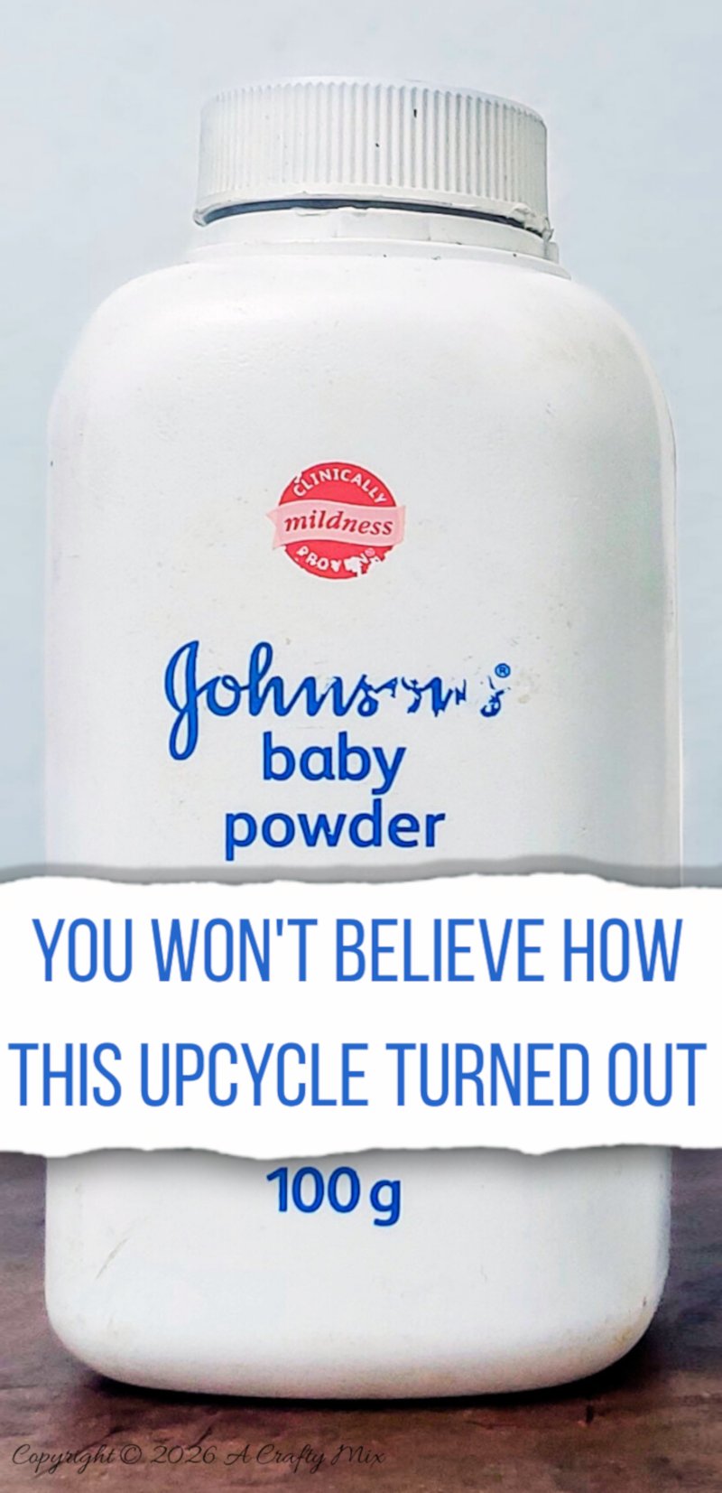 Close up of an empty Johnson&rsquo;s baby powder bottle on a wooden surface with bold text promising a surprising upcycle transformation into a decorative vase.