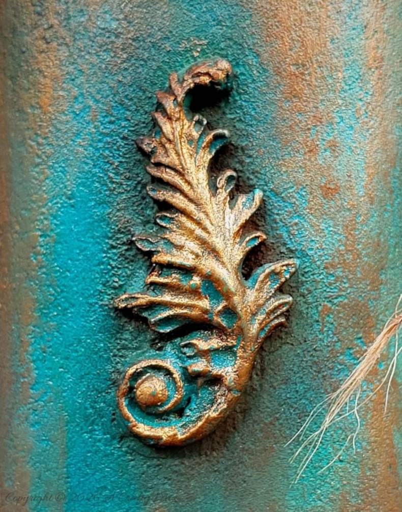 Close up of the a faux verdigris patina on a vase made from an upcycled baby powder bottle.