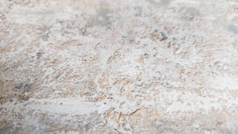 A close up view of a textures canvas with layers of paint peaking through.