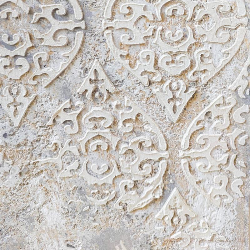 A close up view of the damask texture on top of distress paint layers