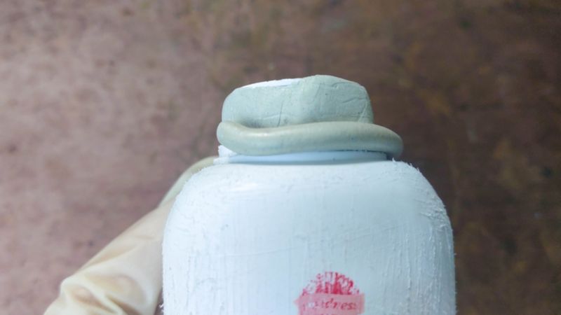 Place the 2-part epoxy clay around the mouth of the bottle.