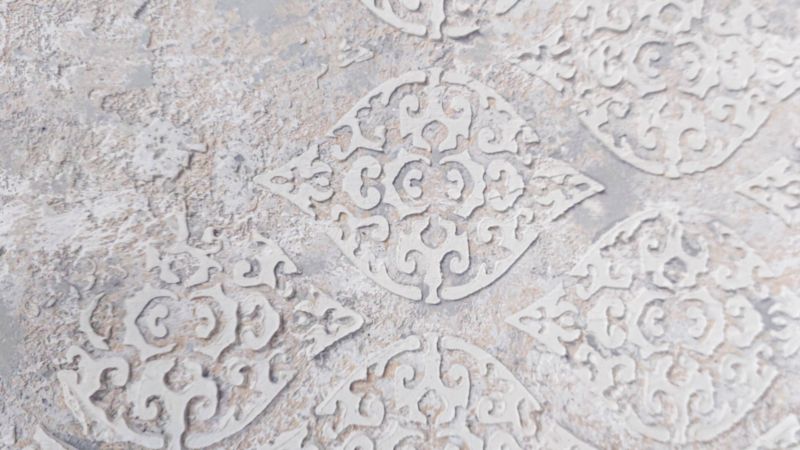 A close up view of the damask texture on top of distress paint layers