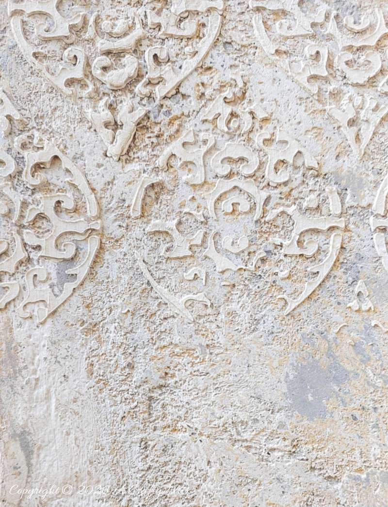A close up view of the damask texture on top of distress paint layers