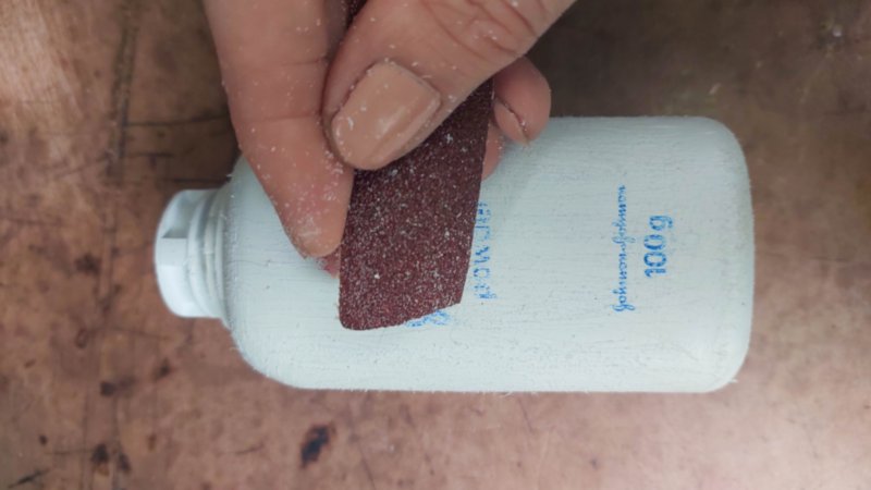 Sand the baby powder bottle with 80-grit sandpaper