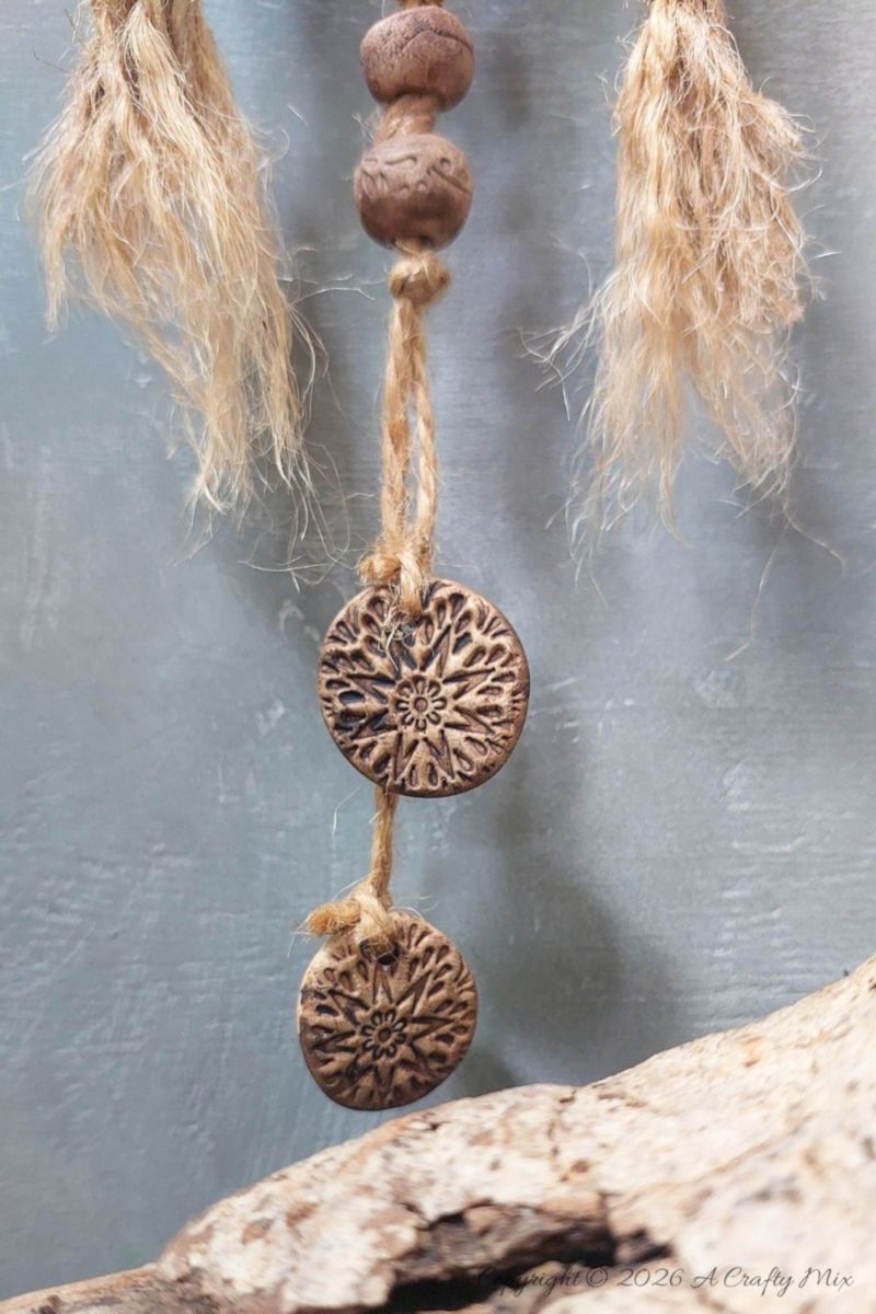 A close up of jute twine tassels and small clay medallion beads