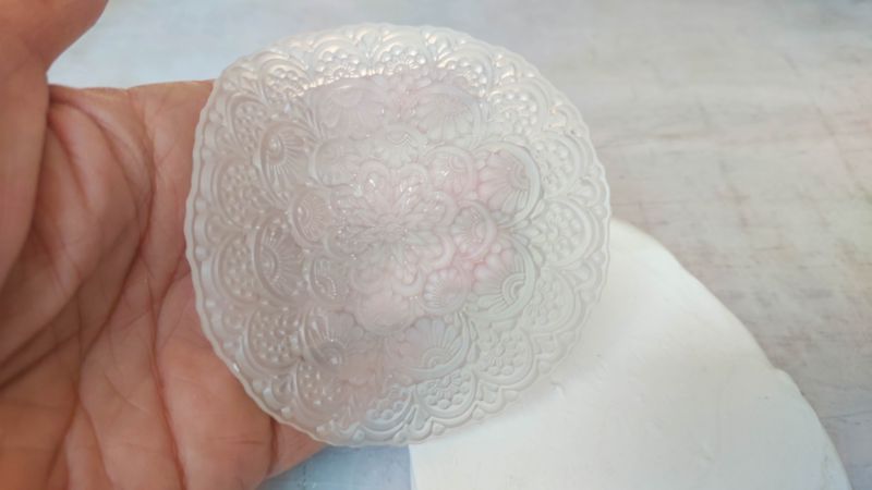 A close up shot of a hand holding a silicone mandala mold