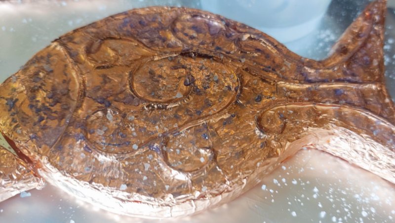 A close up of a copper fish sprinkled with salt.