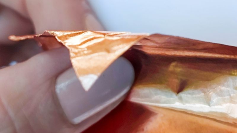 A close up of a hand holding copper tape