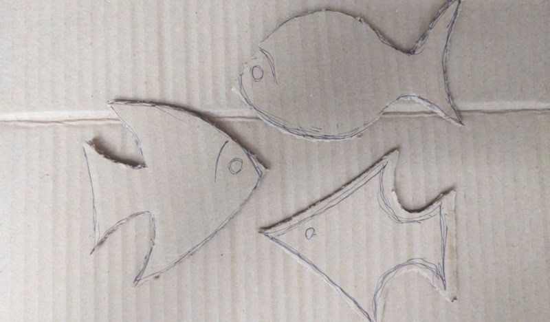 Three simple fish shapes cut out of cardboard