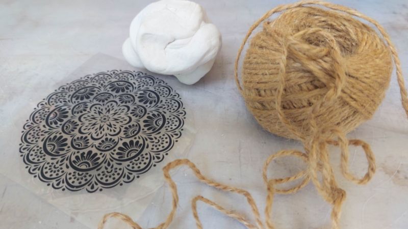 A top down view of a silicone stamp, clay and twine