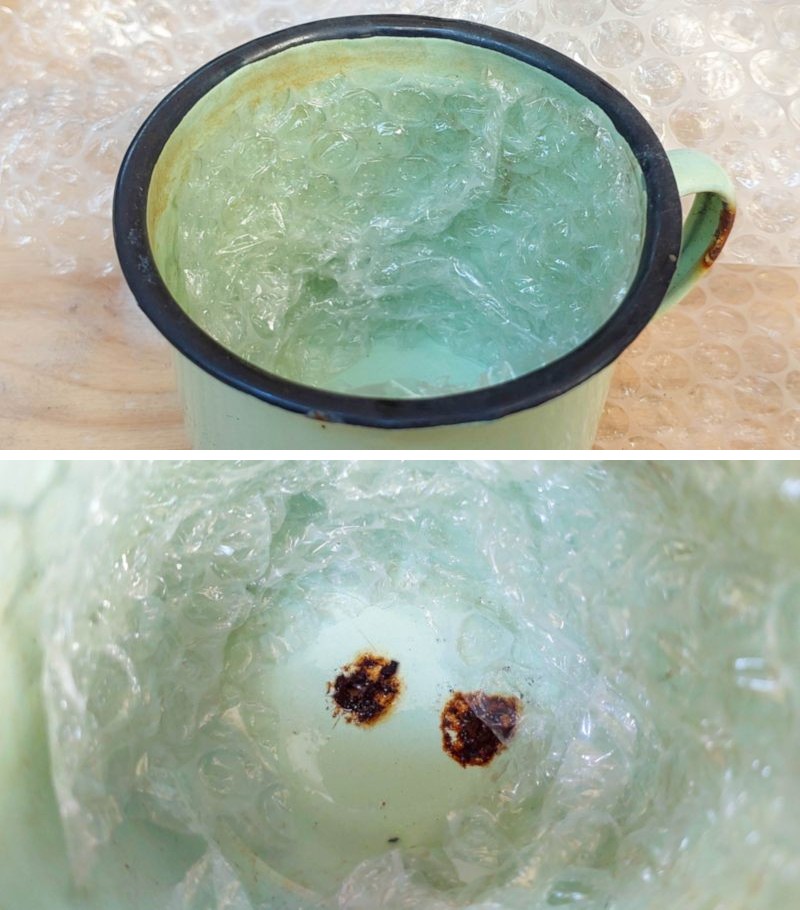 Two drainage holes at the bottom of an enamel cup. The walls of the cup are lined with bubble wrap