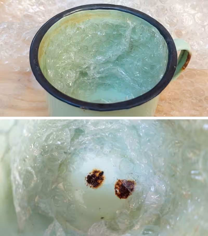 Two drainage holes at the bottom of an enamel cup. The walls of the cup are lined with bubble wrap