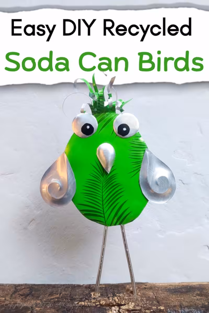 Close up of a bright green DIY, recycled Soda Can Bird made from an aluminium drink can with large eyes and embossed metal wings.
