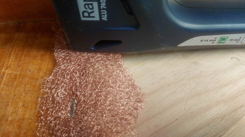 A close up view of a stapler and copper mesh