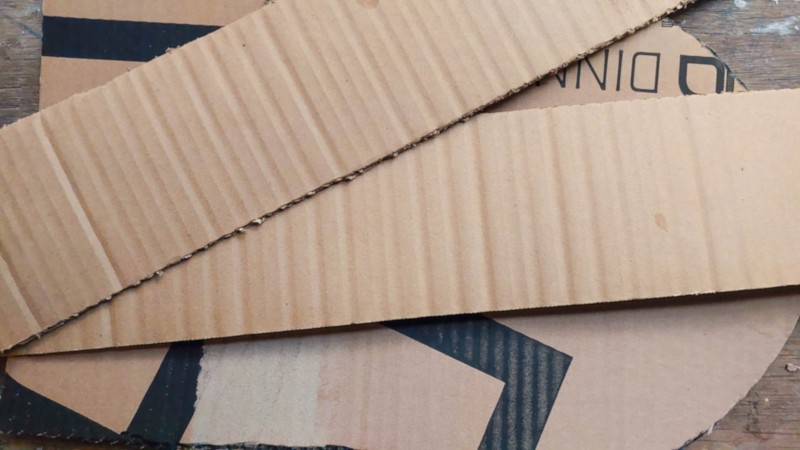 Make a tiny sarcophagus from scrap cardboard for your DIY Halloween mummy. This easy upcycling step shows how simple cardboard strips and a curved base become the shape for a weathered faux-stone tomb. Save it for your next not-too-spooky Halloween craft.