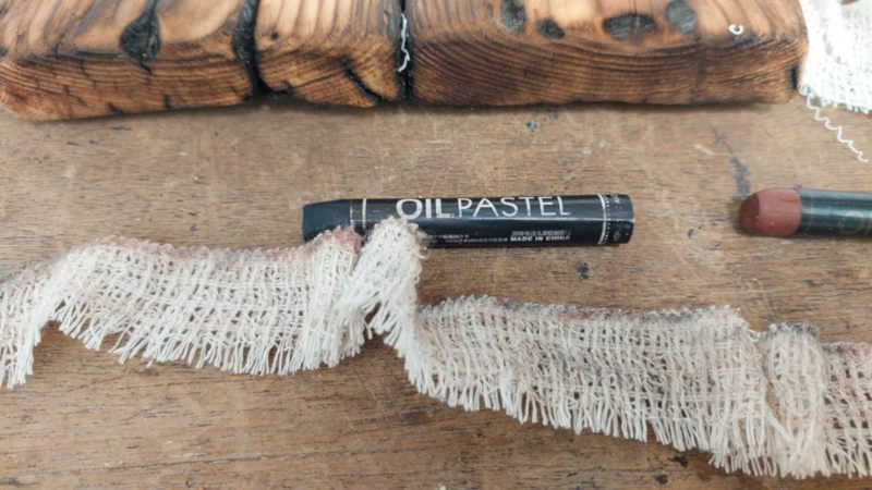 Distress the bandages with oil pastels or rub them in dirt