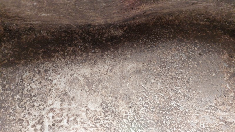 Close-up of the rough, pitted interior of the cardboard sarcophagus