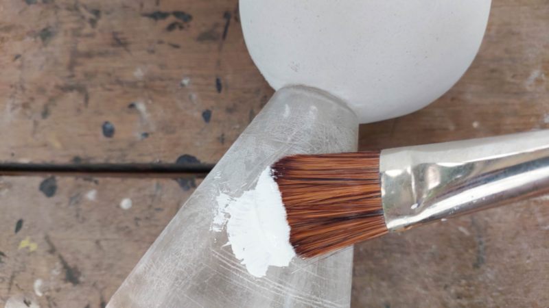 Sand the plastic bottle before painting it white