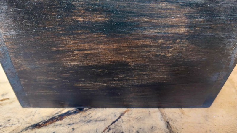 A close up of a wooden planter that has been stained a rich, dark brown and sealed with polywax.