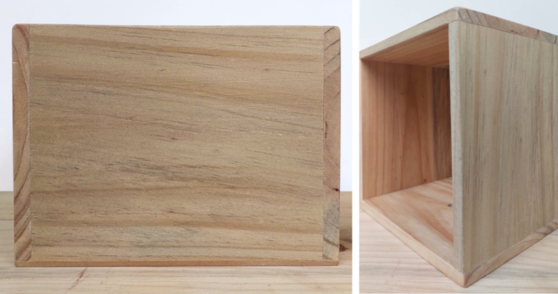 A side view of a square wooden box.