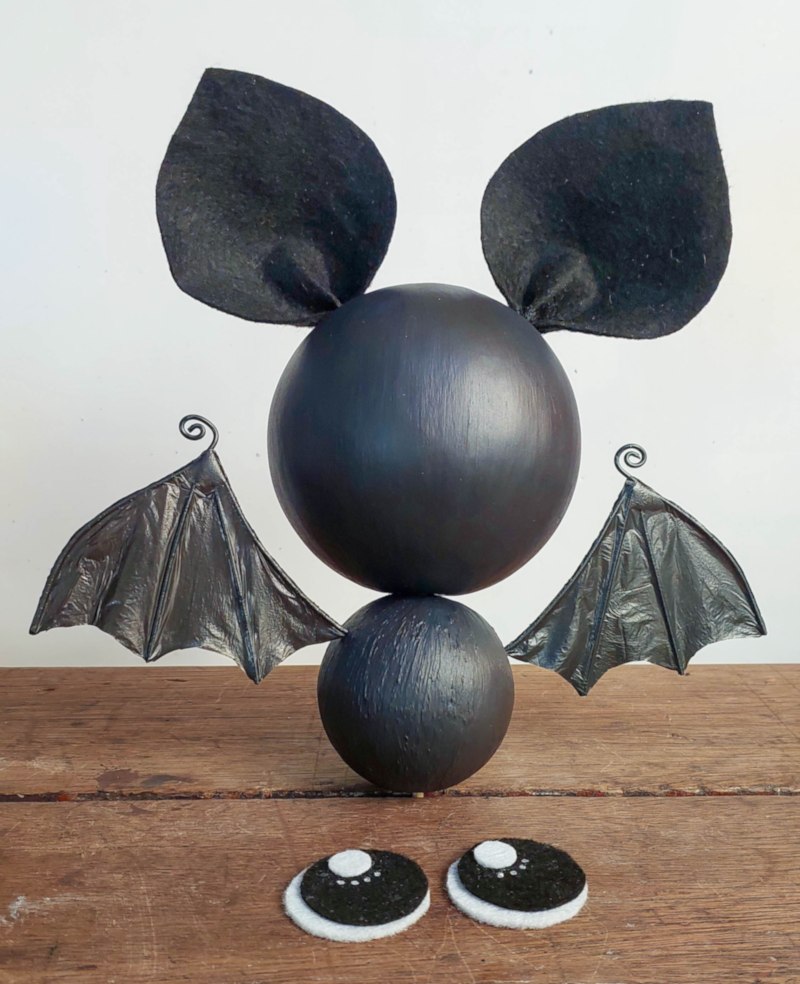 Front view of a cute black hanging bat with recycled plastic bag wings before adding large sparkling eyes.