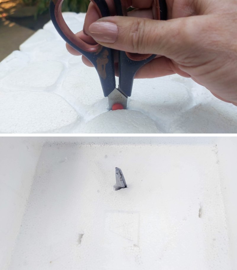 A hand poking holes into an EPS foam cooler with scissors