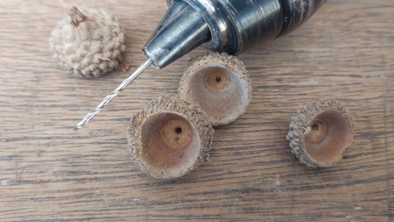 Drill a small hole in the top of the acorn cap