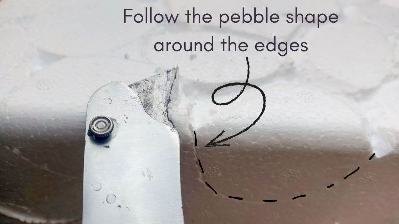 A craft knife carves pebble shapes in a foam cooler.
