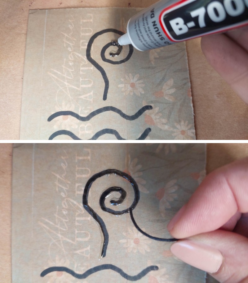 A hand gluing down was cord onto a piece of cardboard
