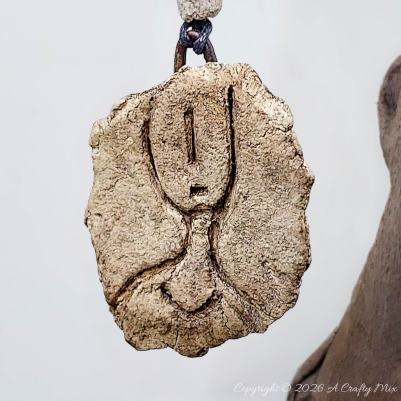 Handmade faux stone petroglyph hanging ornament with clay beads.