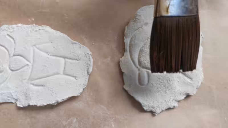 Clay petroglyphs and a paint brush