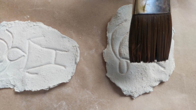 Clay petroglyphs and a paint brush