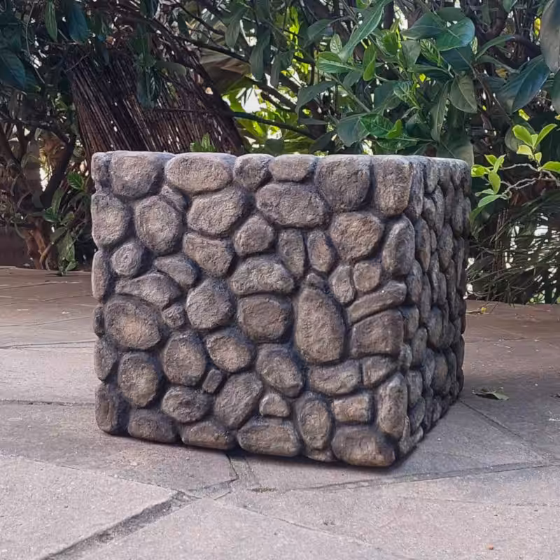 A square box covered in faux pebbles