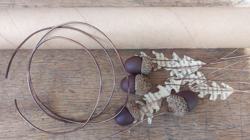Coiled wire, clay acorns and boo page leaves ready to be assembled into a napkin ring