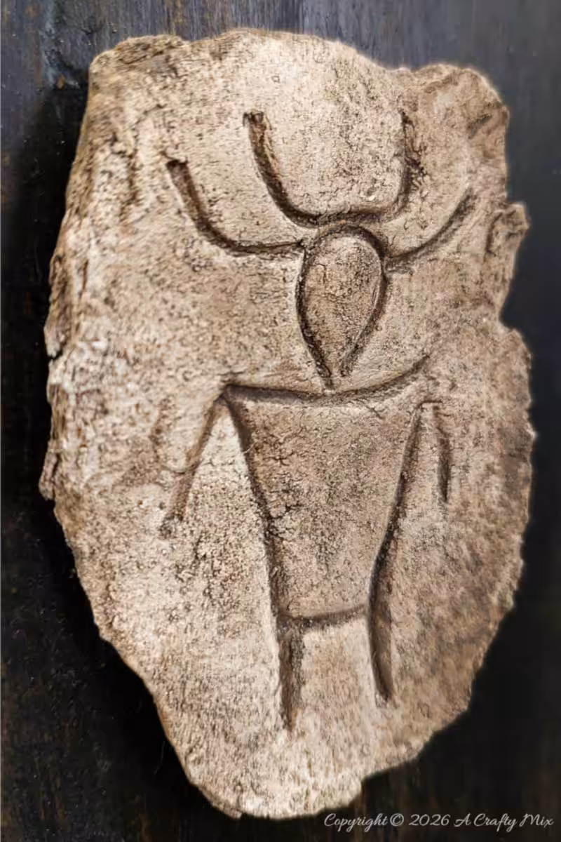Side view of a textured faux stone petroglyph plaque with a stylised figure