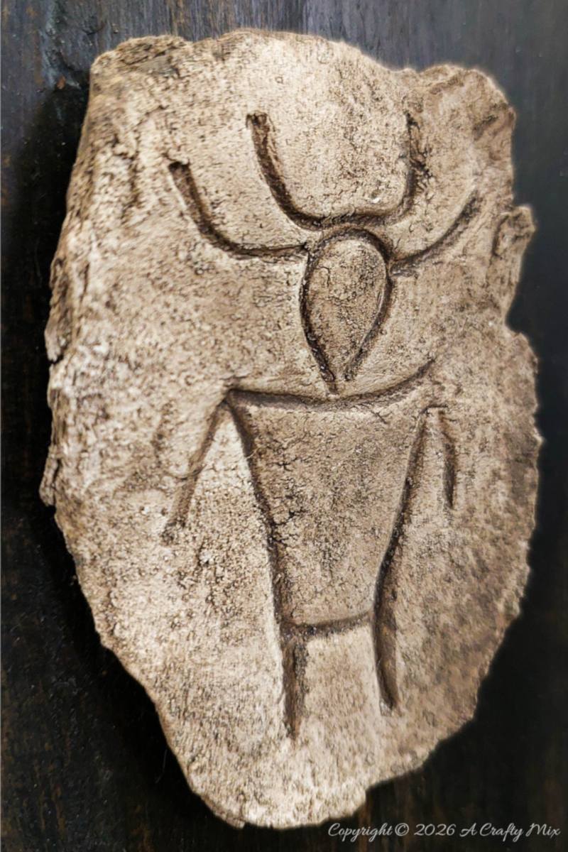 Side view of a textured faux stone petroglyph plaque with a stylised figure