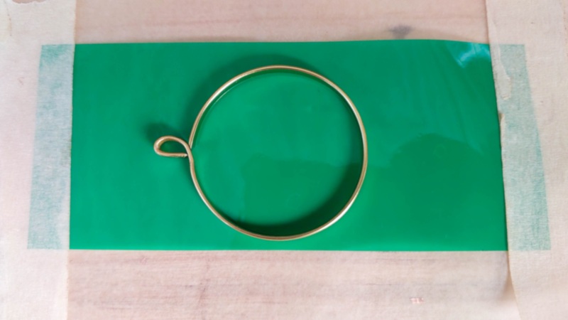 Place the wire ring on the sticky side of a piece of duct tape