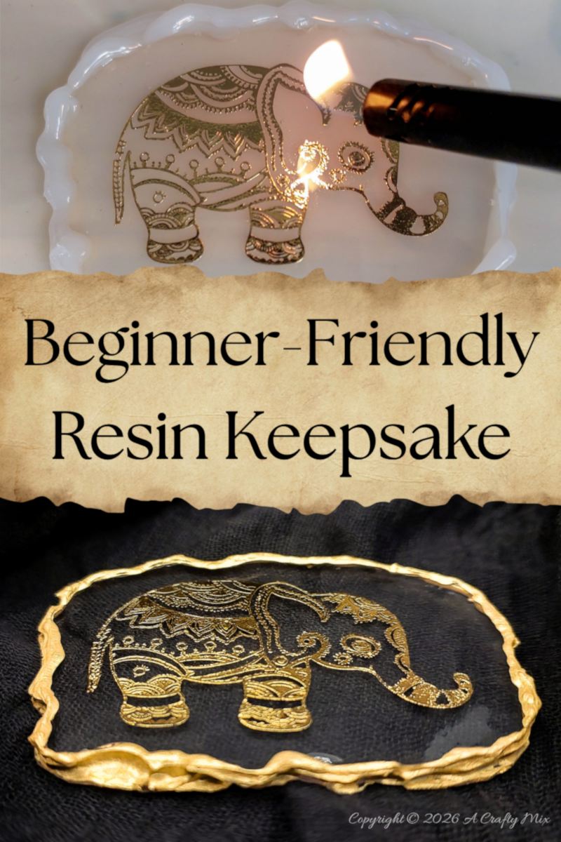 Gold elephant design embedded in clear resin with a textured gold border on dark fabric.