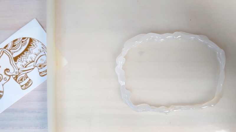 Make a hot glue well or reservoir on a smooth silicone mat for the resin keepsakes
