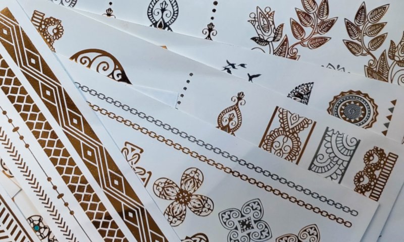A collection of gold temporary tattoos used to make resin keepsakes