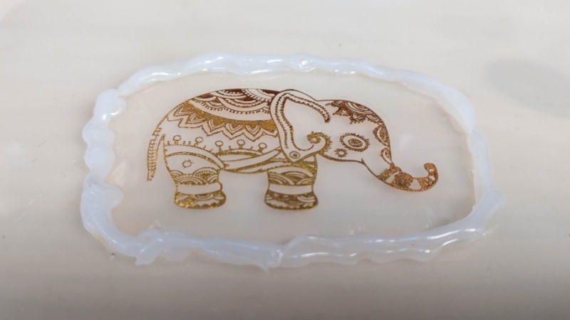A work in process photo of the gold elephant tattoo on a thin layer of resib